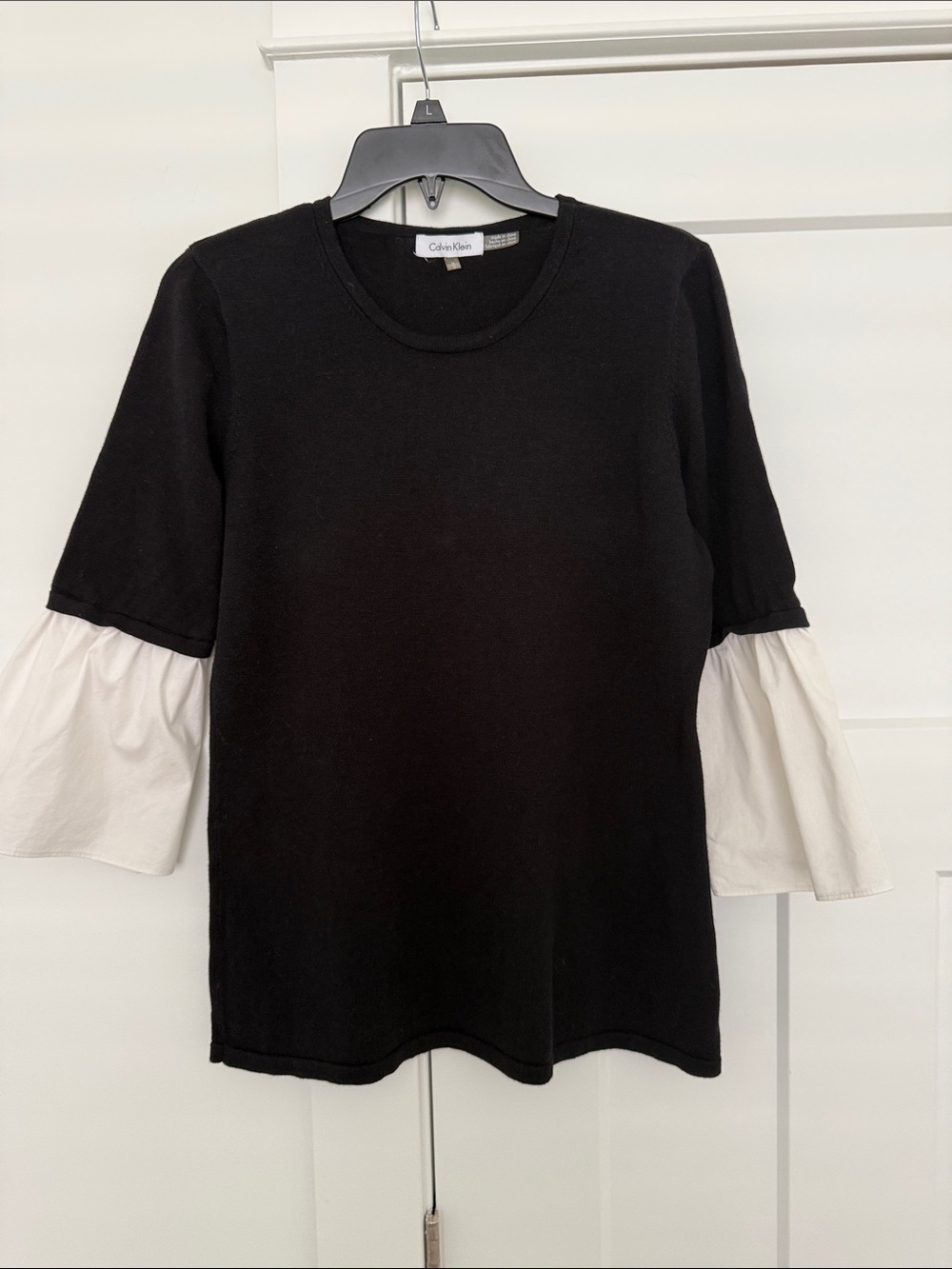 Calvin Klein Black Top with White Ruffle Sleeves. M. ptp 20”. length 27”